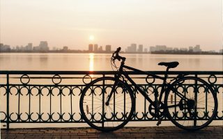 Vélo garé contre une barrière devant un lac